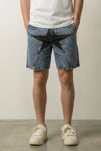 Big Star Patchwork Denim Shorts 'Hoshigata' – light blue washed denim shorts with a large black star patch, front view on model, studio