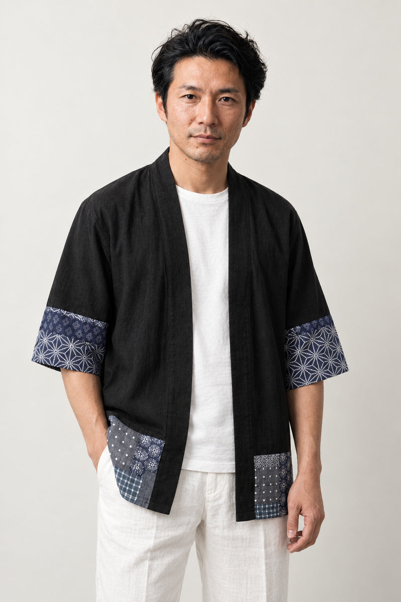 Black Patchwork Kimono Jacket 'Tsugihagi' – black Japanese kimono jacket with indigo boro patchwork print hem and cuffs, unisex haori style cardigan, front view on model