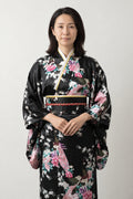 Black Peacock Kimono 'Oborozuki' – black women's kimono robe with pink peacock and floral print and obi sash, long Japanese satin-look kimono, front view on model