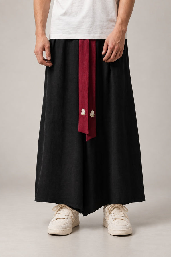 Black Samurai Style Hakama 'Musha' – black pleated samurai style hakama with red front ties, traditional Japanese wide leg trousers, front view on model