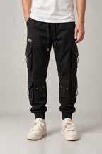 Black Techwear Cargo Pants 'Kageboshi' – black techwear cargo pants with multiple pockets and straps, Japanese streetwear trousers, front view on model
