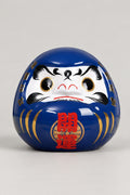 Blue Daruma Doll 'Umidaruma' – royal blue glossy ceramic daruma doll with both eyes painted, gold streaks and red kanji for opening luck on the belly, Japanese good luck doll, studio view
