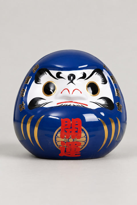 Blue Daruma Doll 'Umidaruma' – royal blue glossy ceramic daruma doll with both eyes painted, gold streaks and red kanji for opening luck on the belly, Japanese good luck doll, studio view