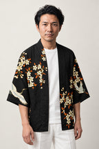 Crane and Red Sun Haori Jacket 'Chitose' – black haori jacket with white cranes, cherry blossom and red sun print, unisex Japanese kimono style cardigan, front view on model