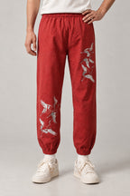 Crane Flock Embroidered Pants 'Tsurumure' – red version of the crane flock embroidered joggers, front view on model