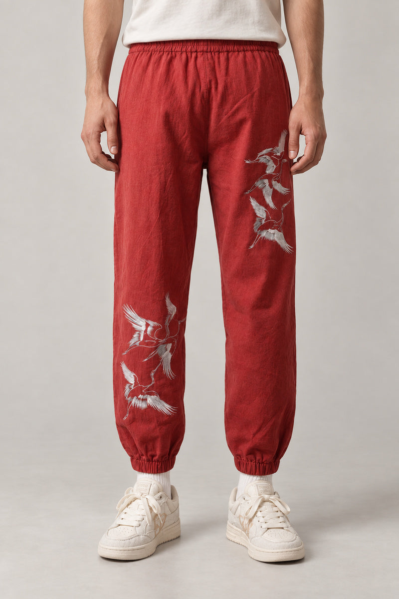Crane Flock Embroidered Pants 'Tsurumure' – red crane flock embroidered joggers, front view on model
