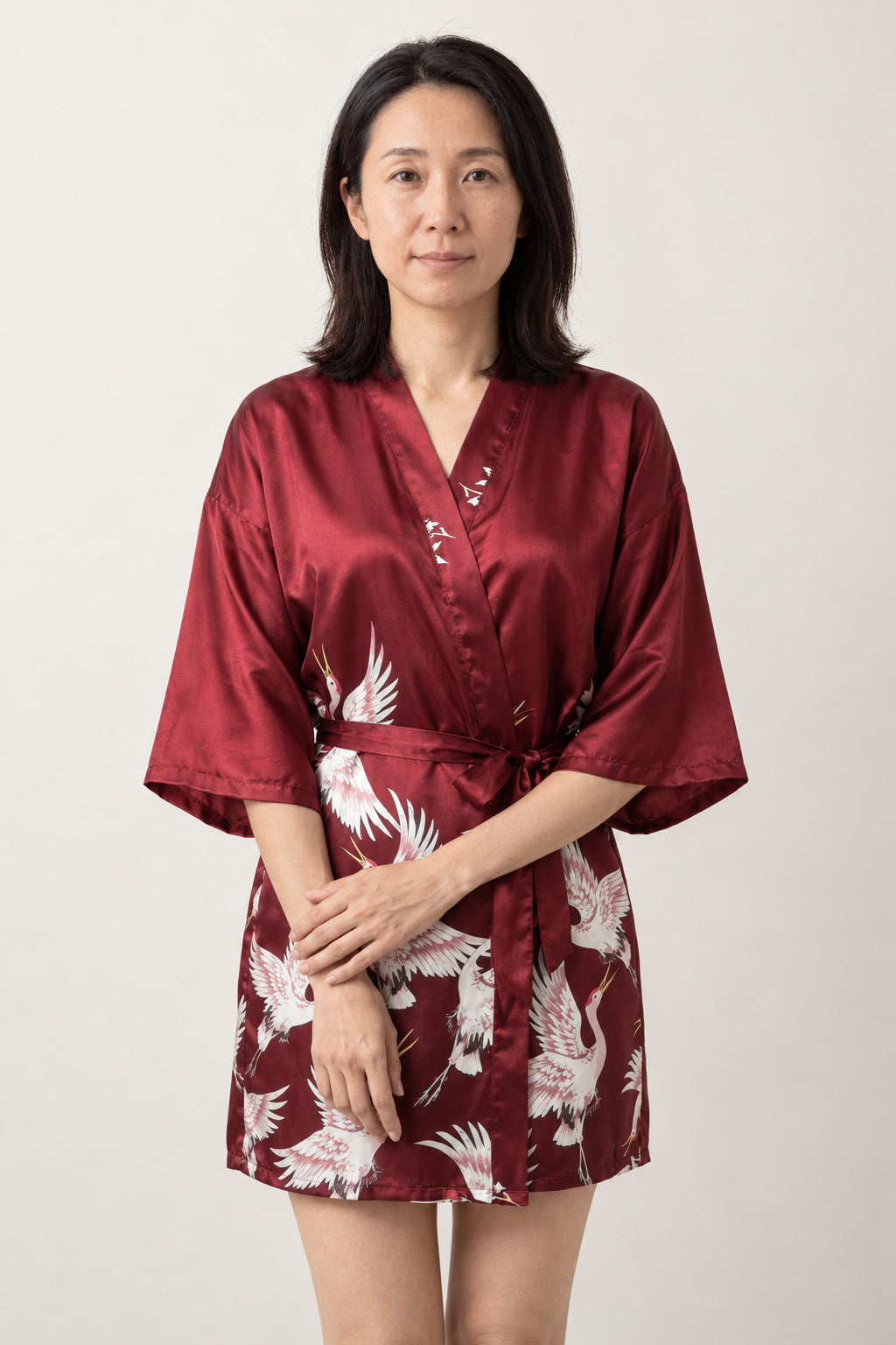 Crane Print Satin Nightie 'Akatsuru' – burgundy red women's short satin-look kimono nightie with crane print and tie belt, Japanese robe, front view on model