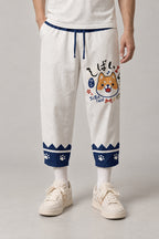 Cropped Japanese Print Pants 'Jukkei' – white cropped pants with shiba inu and paw print hem, Japanese print harem trousers, front view on model