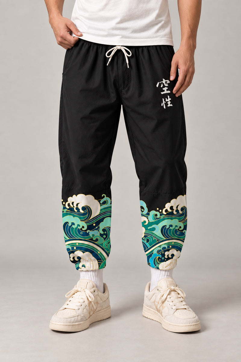 Cropped Japanese Print Pants 'Jukkei' – black cropped pants with wave print hem and kanji, front view on model