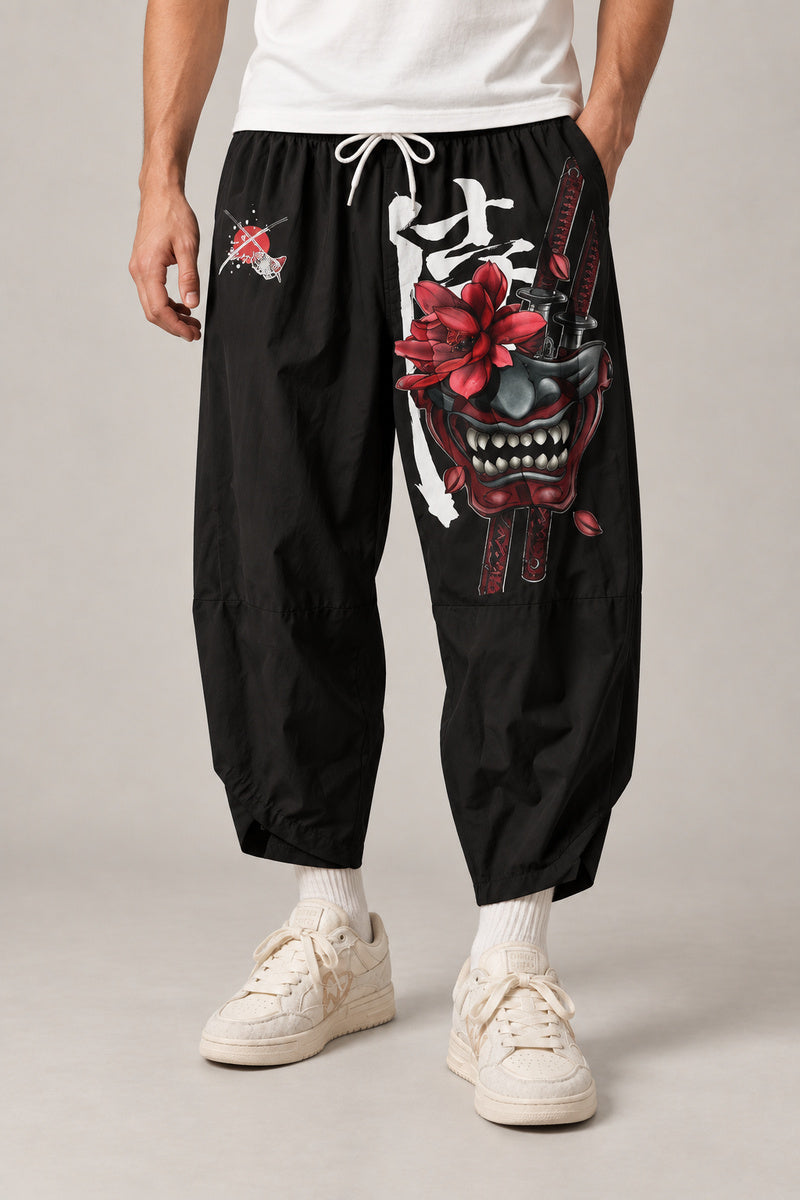 Cropped Japanese Print Pants 'Jukkei' – black cropped pants with oni mask print, front view on model
