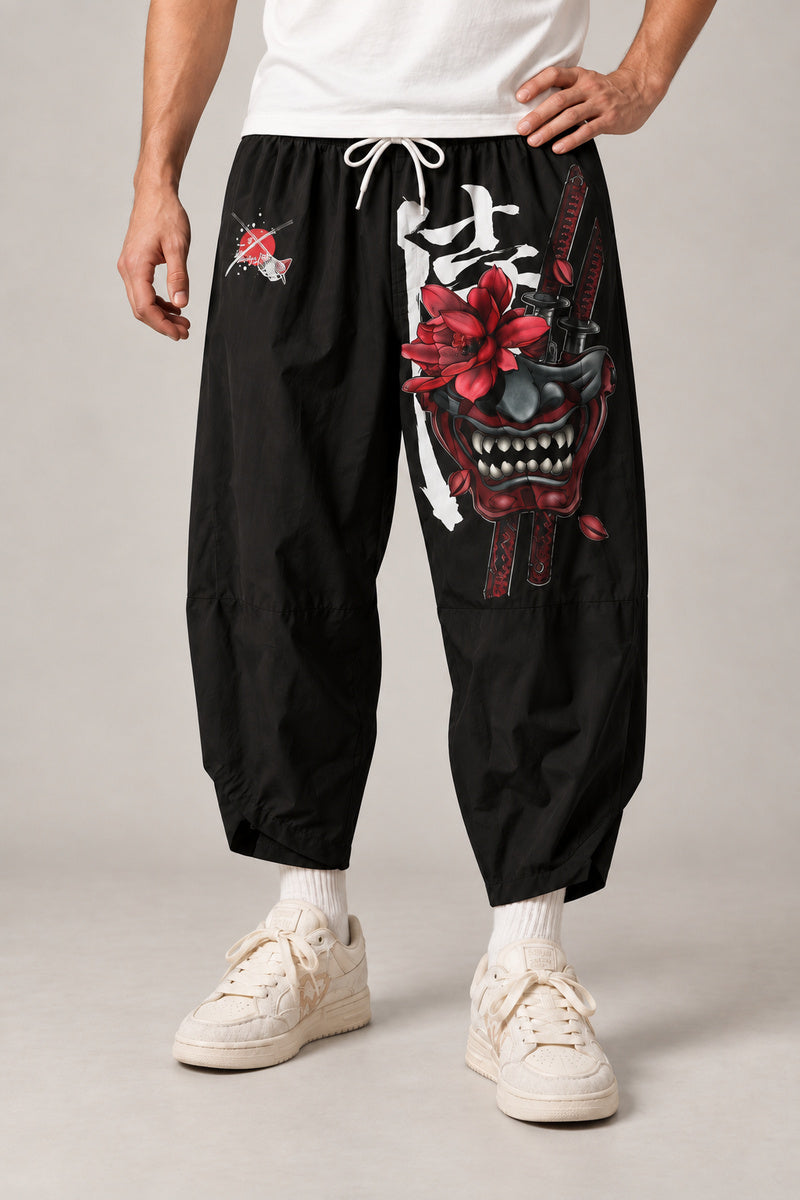 Cropped Japanese Print Pants 'Jukkei' – black cropped pants with oni demon mask print, front view on model
