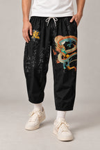Cropped Japanese Print Pants 'Jukkei' – black cropped pants with golden dragon print, front view on model