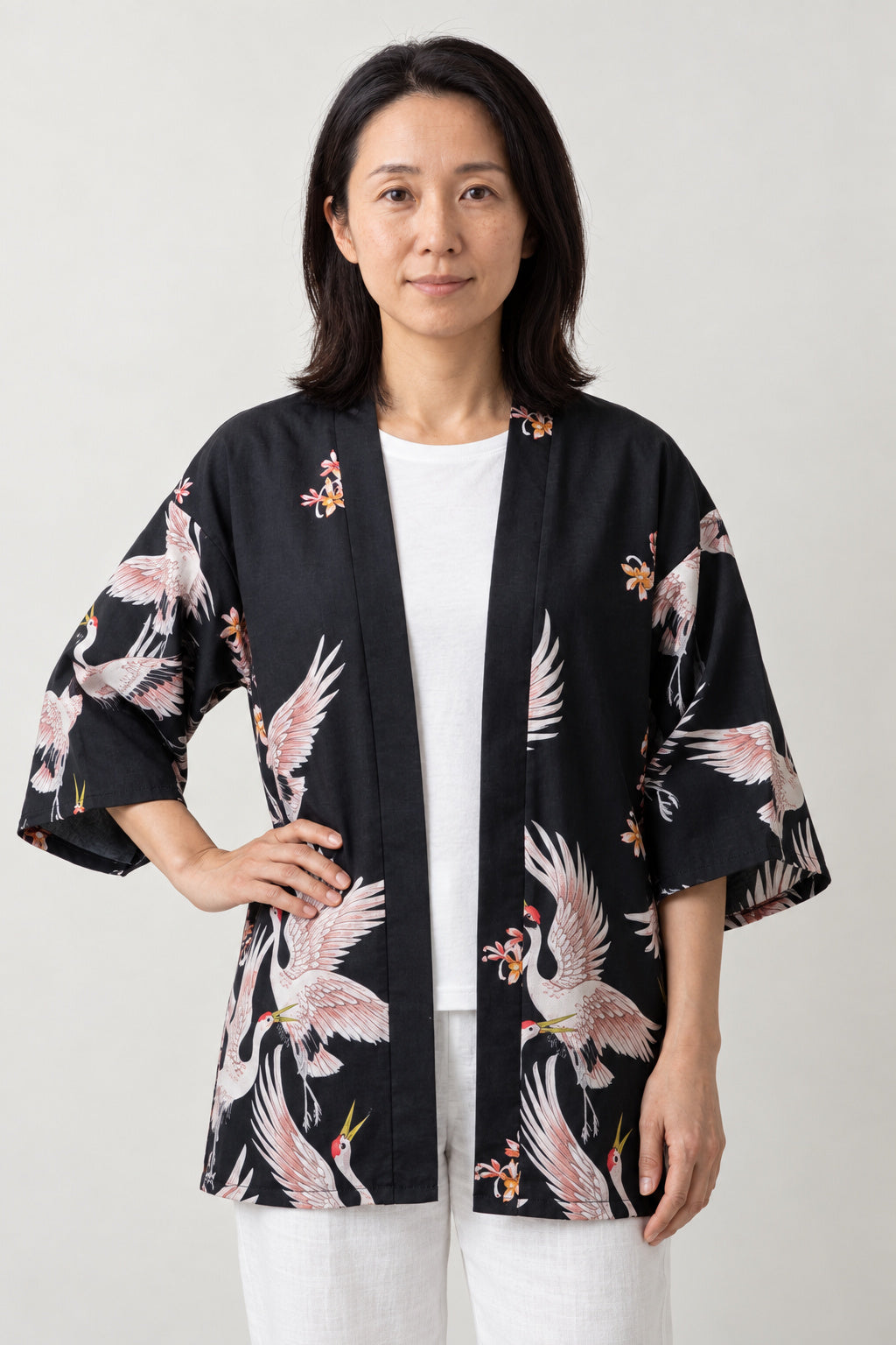 Flying Crane Kimono Jacket 'Usubeni' – black women's kimono jacket with pink flying crane print, Japanese haori style cardigan, front view on model