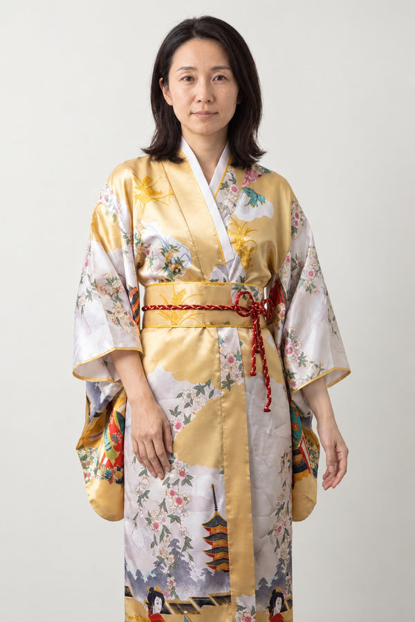Gold Peacock Kimono Robe 'Ogon' – gold yellow women's kimono robe with peacock, pagoda and floral print and red obi, long Japanese satin-look kimono, front view on model