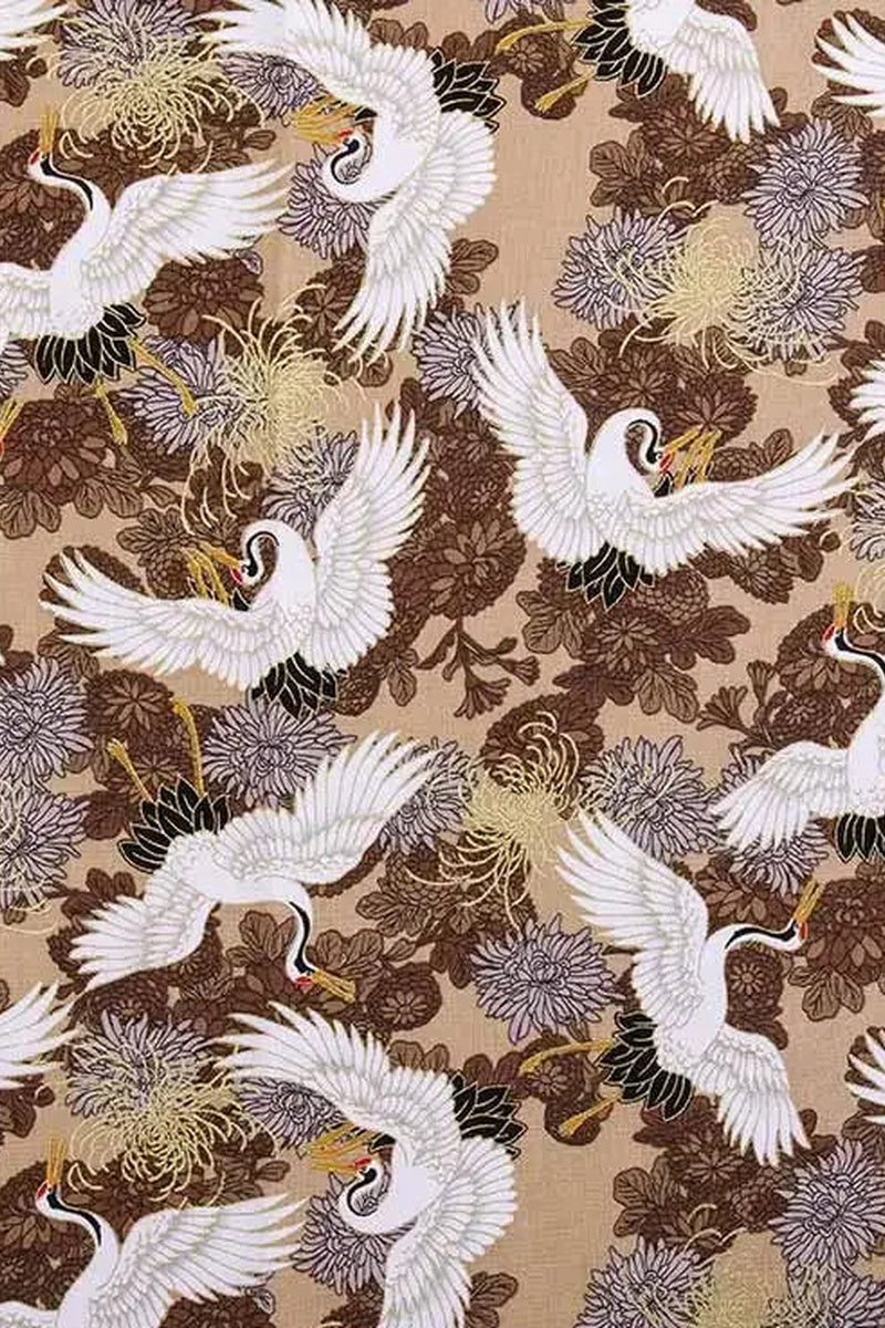 Golden Crane Furoshiki Fabric 'Kinzuru' – beige furoshiki printed with white cranes in flight over brown and gold chrysanthemums, Japanese furoshiki wrapping cloth 50 by 145 cm, close-up of the print