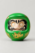 Green Daruma Doll 'Sachi' – green matte ceramic daruma doll with blank eyes to paint and a gold character on the belly, Japanese wishing doll, studio view
