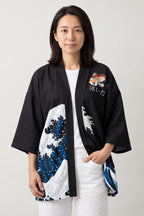 Hokusai Wave Kimono Jacket 'Okinami' – black women's kimono jacket with Hokusai great wave print on the hem, Japanese haori style cardigan, front view on model