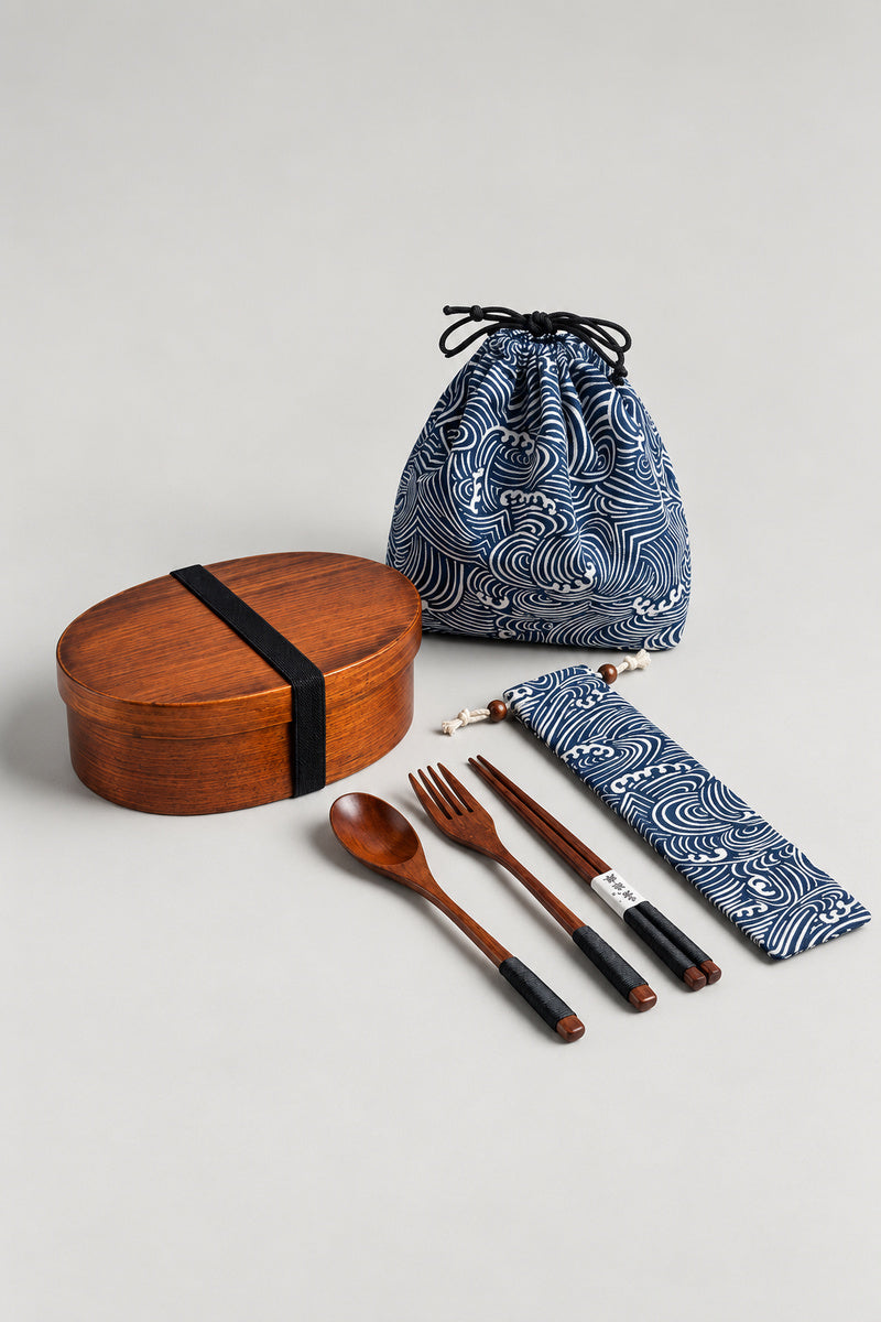Japanese Bento Box 'Magewappa' – oval bent-wood bento lunch box with black strap, navy wave print drawstring bag and wooden chopsticks, spoon and fork in a pouch, studio view