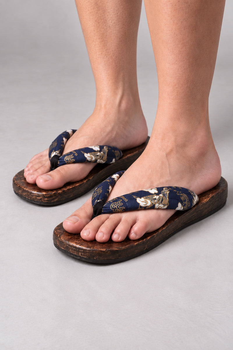 Japanese Flip Flops 'Karakoro' – wooden flip flops with navy floral print thong, flat Japanese wooden sandals worn barefoot, front view on model