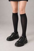 Japanese School High Socks 'Ashimoto' – black over-the-calf Japanese school socks worn with loafers, front view on model