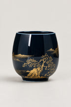 Japanese Tea Cup 'Yunomi' – deep blue glazed yunomi tea cup with gold landscape of pines, hills and a boat, Japanese handleless tea cup, studio view