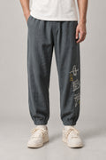 Kanji Calligraphy Jogger Pants 'Fude' – grey joggers with kanji calligraphy print on the leg, Japanese streetwear pants, front view on model