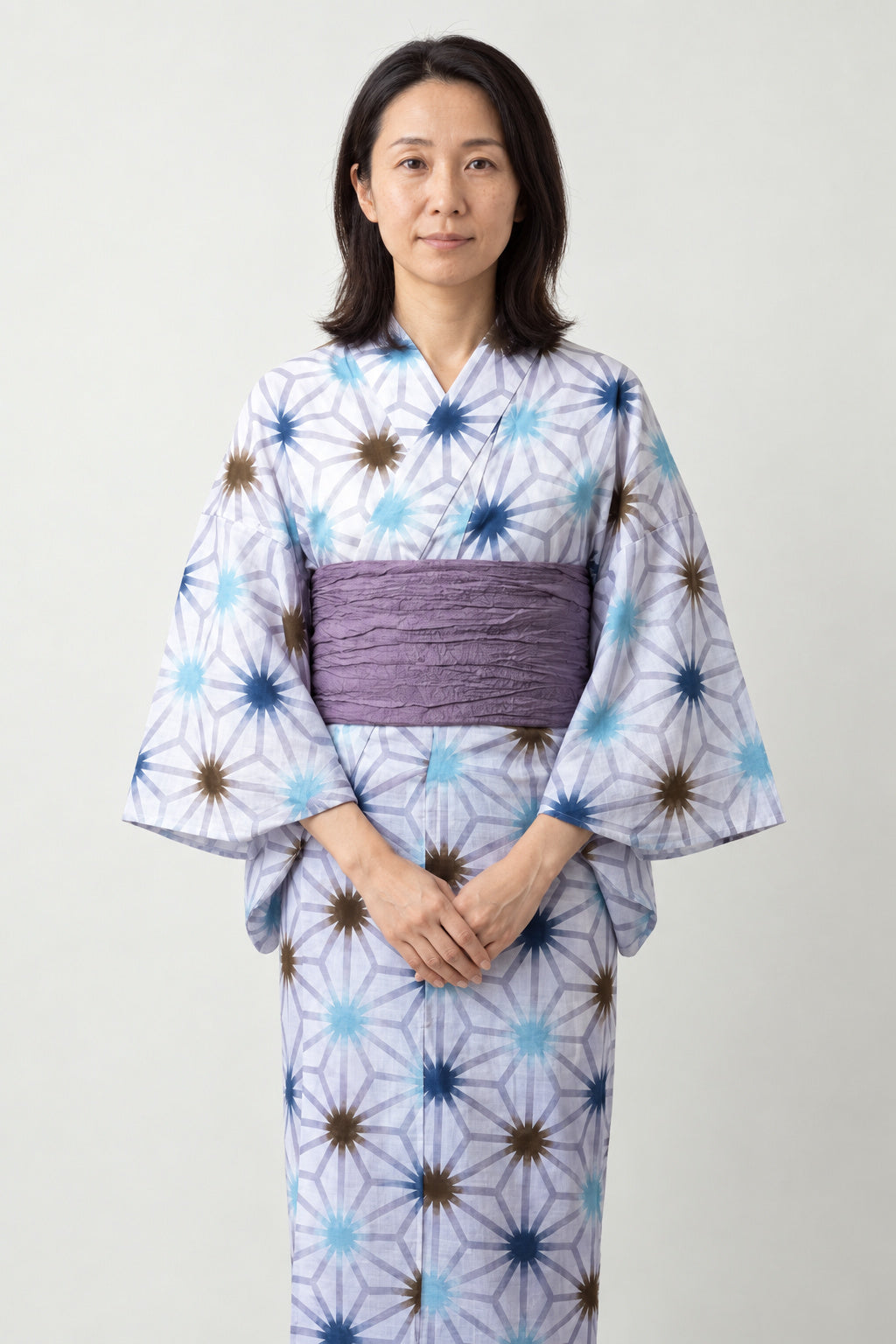 Lilac Long Japanese Kimono 'Fujiiro' – white women's long kimono with lilac star and hemp leaf print and purple obi belt, traditional Japanese yukata, front view on model