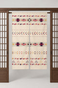 Long Geometric Noren Curtain 'Kasuri' – cream noren with bands of geometric pattern in red, plum and gold, split Japanese noren door curtain hung on a rod between sliding screens, studio view