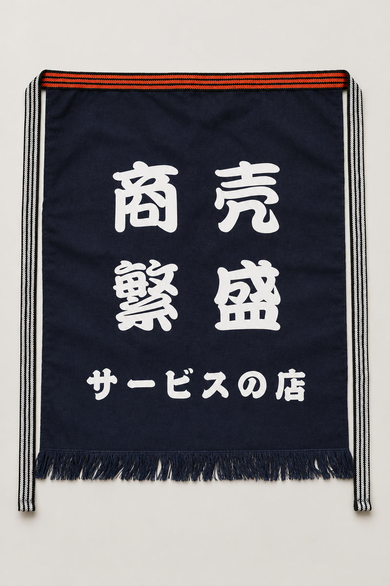 Maekake – indigo maekake apron printed with the kanji for prosperous business and service, traditional Japanese sake brewery waist apron with fringed hem, studio view