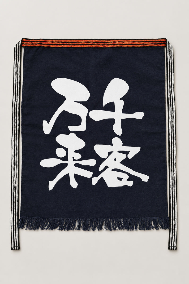 Maekake – indigo maekake apron printed with the kanji for a thousand customers, traditional Japanese sake brewery waist apron with fringed hem, studio view