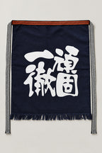 Maekake – indigo maekake apron printed with the kanji for steadfast and thorough, traditional Japanese sake brewery waist apron with fringed hem, studio view