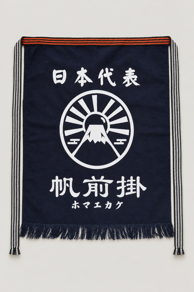 Maekake – indigo maekake apron printed with a rising sun crest and the kanji for maekake, traditional Japanese sake brewery waist apron with fringed hem, studio view