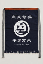 Maekake – indigo maekake apron printed with a fish crest and the kanji for prosperous business, traditional Japanese sake brewery waist apron with fringed hem, studio view