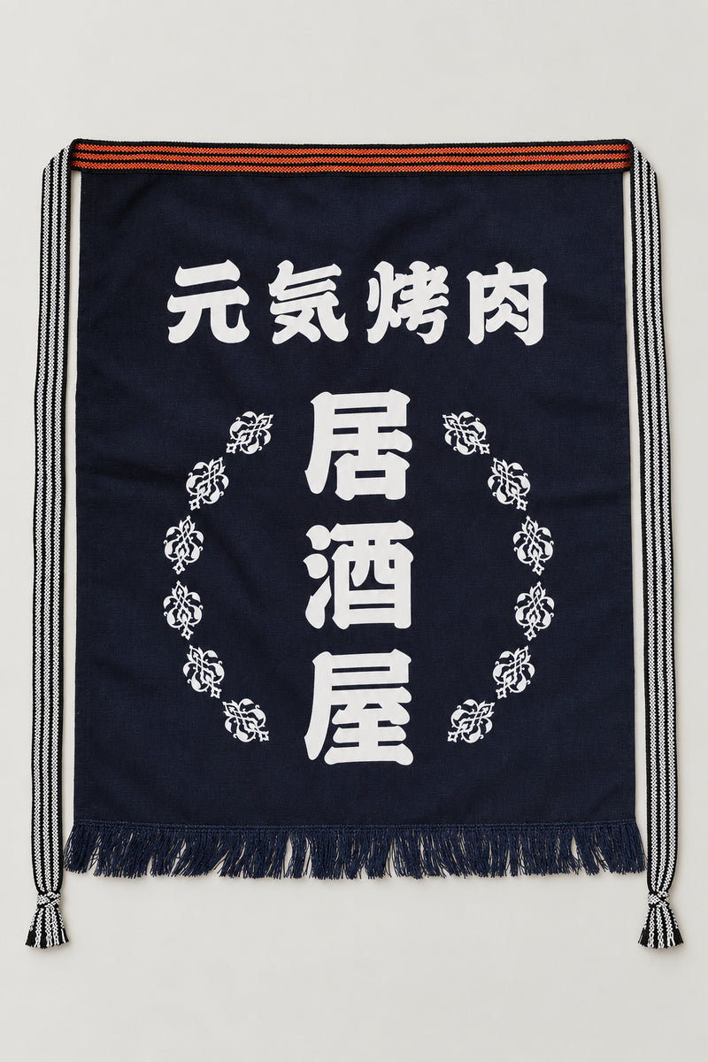 Maekake – indigo maekake apron printed with the kanji for izakaya and a wreath, traditional Japanese sake brewery waist apron with fringed hem, studio view