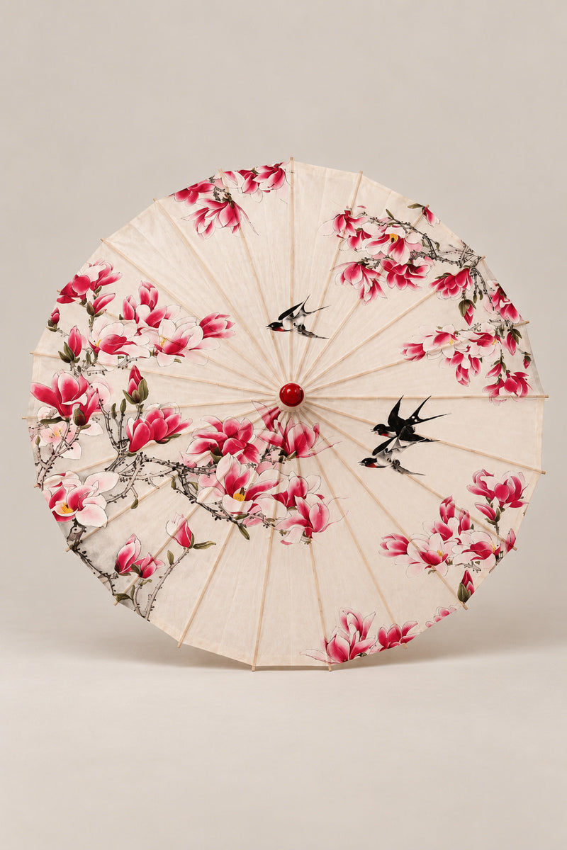 Magnolia Japanese Style Umbrella 'Mokuren' – cream parasol printed with pink magnolia branches and two swallows, Japanese wagasa parasol with wooden frame and paper-effect canopy, open, studio view