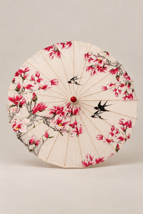 Magnolia Japanese Style Umbrella 'Mokuren' – cream parasol printed with pink magnolia branches and two swallows, Japanese wagasa parasol with wooden frame and paper-effect canopy, open, studio view
