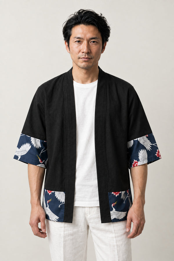 Men's Black Crane Border Cardigan 'Hakkaku' – black men's kimono cardigan with navy crane print border on hem and cuffs, Japanese haori style jacket, front view on model
