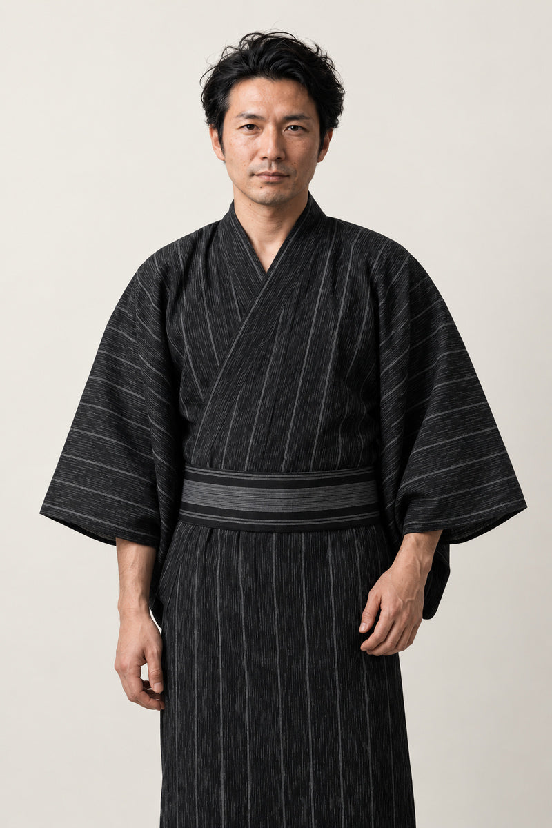 Men's Black Striped Yukata 'Nubatama' – black pinstripe men's yukata with black obi belt, traditional Japanese kimono robe for men, full length, front view on model