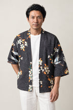 Men's Crane and Sun Kimono Jacket 'Asayake' – black men's kimono jacket with cranes, cherry blossom and red sun print, Japanese haori cardigan, front view on model