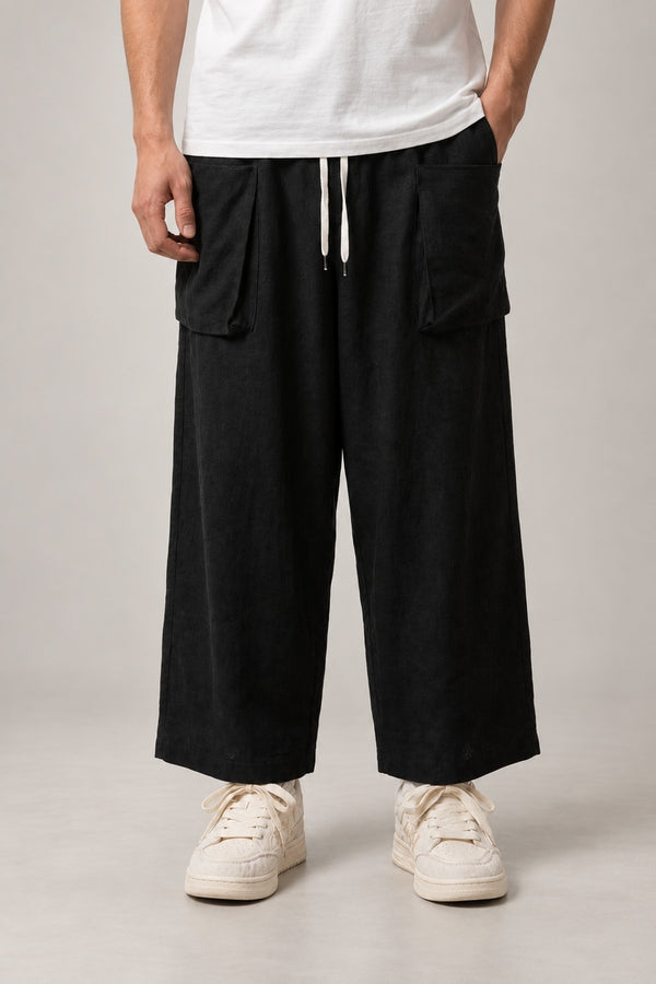 Men's Cropped Hakama Pants 'Sumiiro' – black cropped wide leg hakama pants with drawstring and pockets, men's Japanese style trousers, front view on model