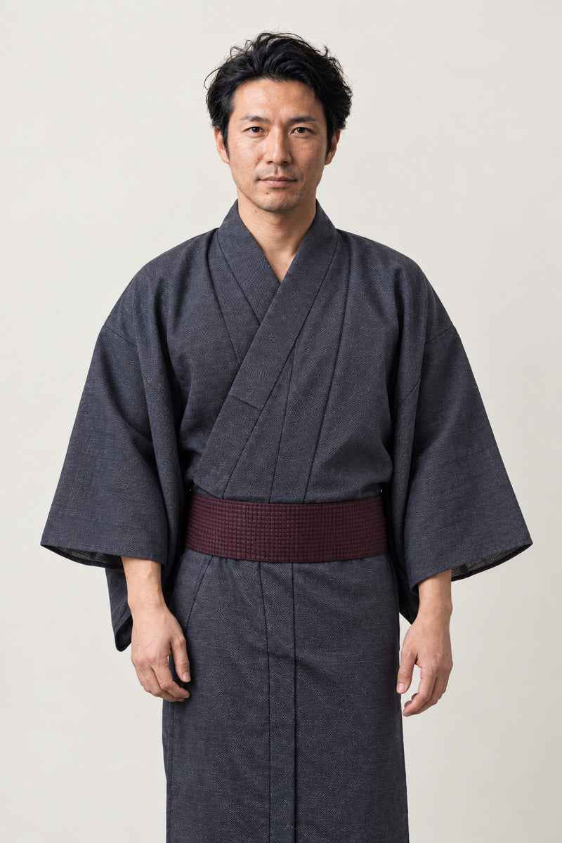 Men's Solid Kimono Robe 'Ainezu' – charcoal grey men's solid kimono robe with dark red obi belt, plain traditional Japanese yukata, front view on model