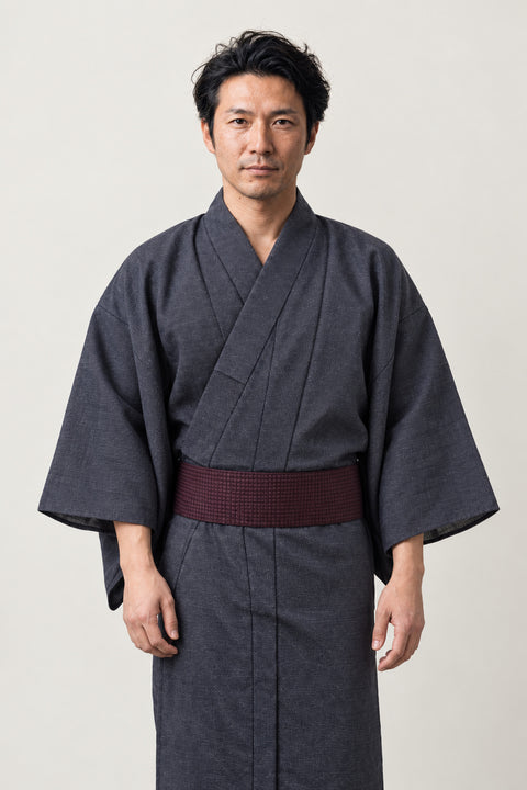 Men's Solid Kimono Robe 'Ainezu' – charcoal grey men's solid kimono robe with dark red obi belt, plain traditional Japanese yukata, front view on model