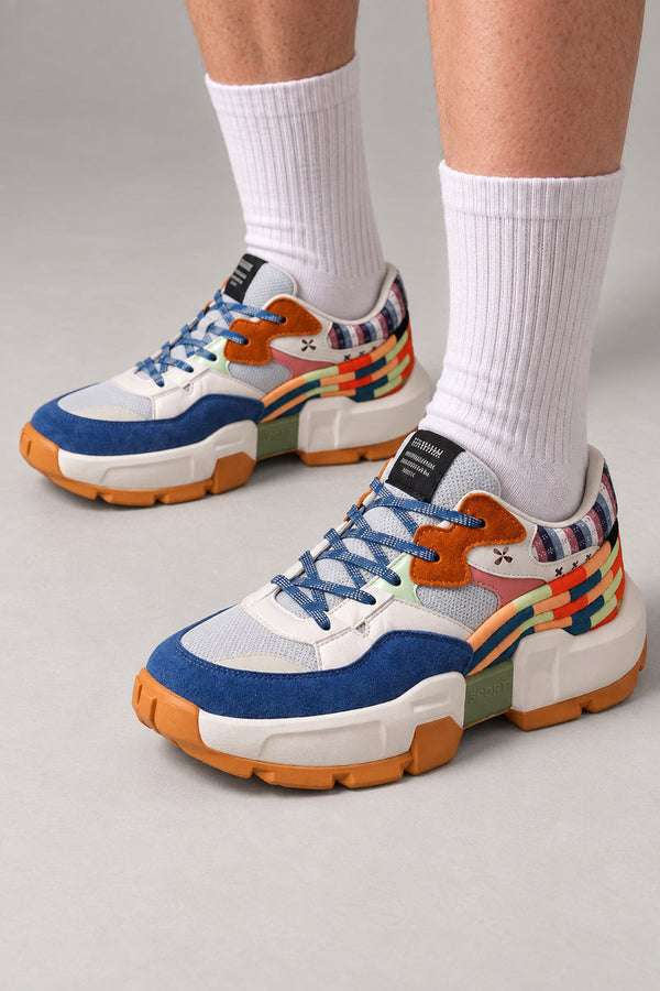 Multicolour Patchwork Sneakers 'Iroasobi' – blue and orange multicolour patchwork sneakers with striped heel, Japanese streetwear sneakers worn with white socks, on model