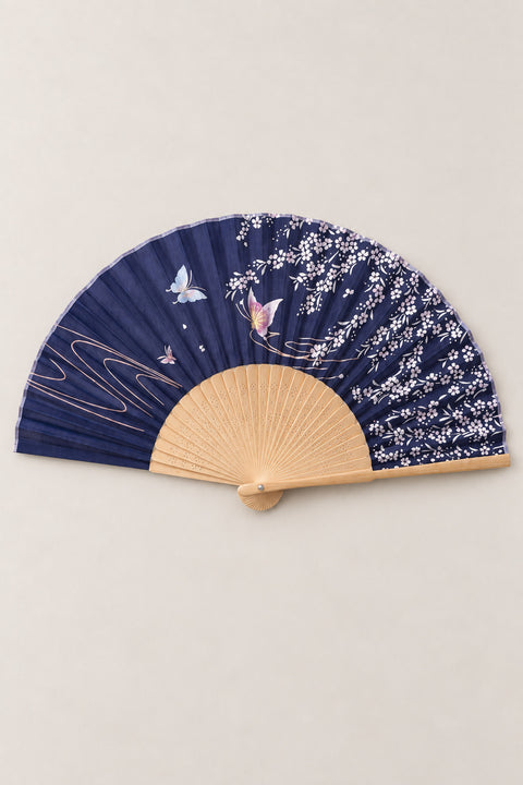 Navy Blossom Bamboo Fan 'Yozora' – folding fan printed with white cherry blossom and butterflies on navy, Japanese folding sensu fan with bamboo ribs, open, studio view