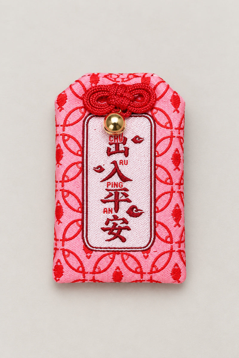 Omamori – red brocade omamori amulet with kanji for family safety and pink pattern, Japanese lucky charm, studio view