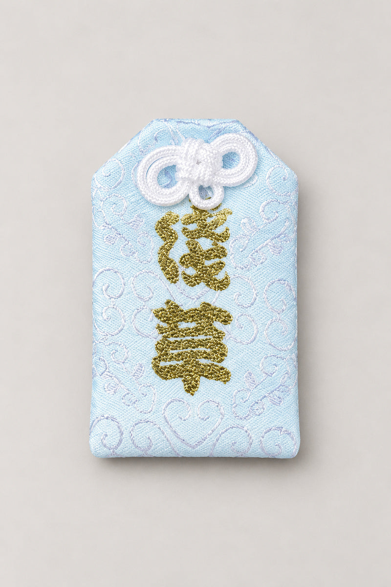 Omamori – pale blue brocade omamori amulet with gold kanji, Japanese lucky charm for the young, studio view