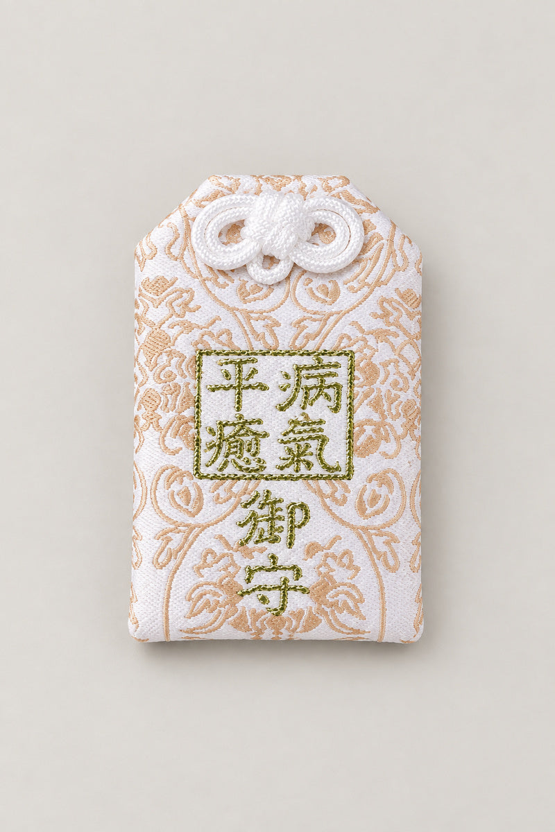 Omamori – cream brocade omamori amulet with gold kanji for recovery from illness, Japanese lucky charm, studio view