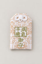 Omamori – cream brocade omamori amulet with gold kanji for recovery from illness, Japanese lucky charm, studio view