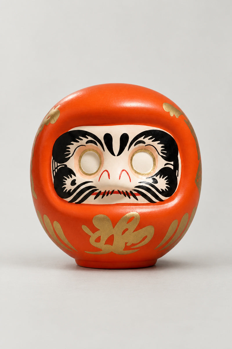 Orange Daruma Doll 'Hiakari' – orange matte ceramic daruma doll with blank eyes to paint and a gold character on the belly, Japanese wishing doll, studio view