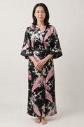 Peacock and Peony Dressing Gown 'Kuroshou' – black women's long satin-look kimono dressing gown with peacock and peony print, Japanese robe, front view on model